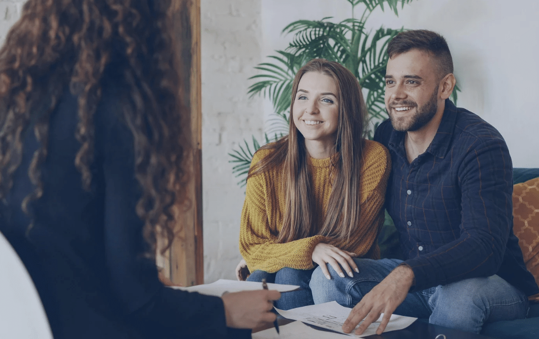 REALTOR® at desk with clients
